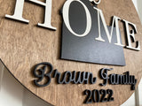 Round wood sign with a silhouette of Idaho and the words welcome HOME going through it.  Family name at the bottom in black lettering.