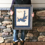 Female Business Owner in Idaho holding a 17x21" Barnwood Framed 3D Lake Art of Hayden Lake Idaho
